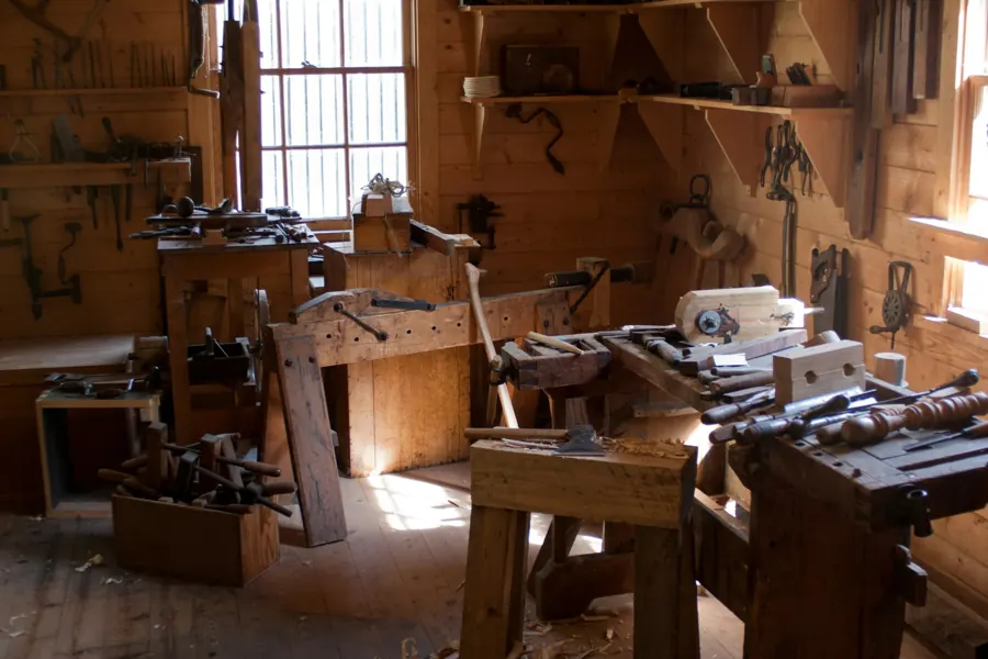 Les établis et les outils à main rangés au mur de l'atelier