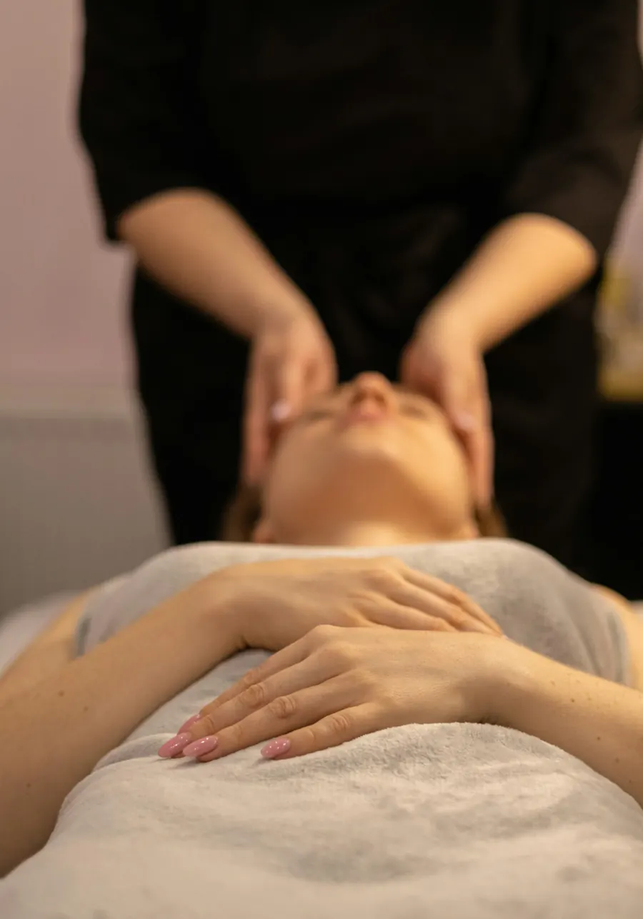 Une cliente allongée, les yeux fermés, pendant un soin du visage