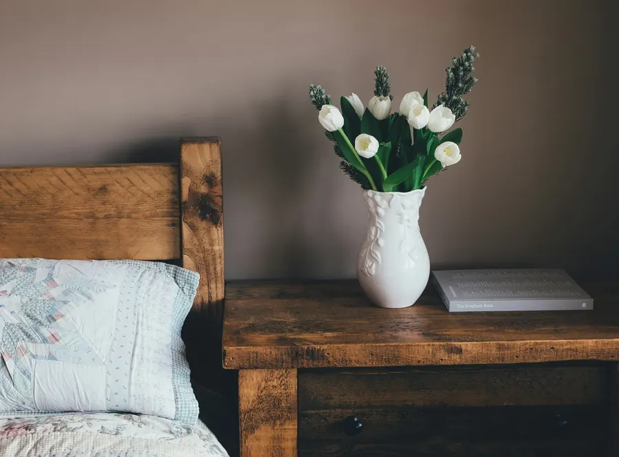 Une chambre au lit en bois, bouquet de tulipes